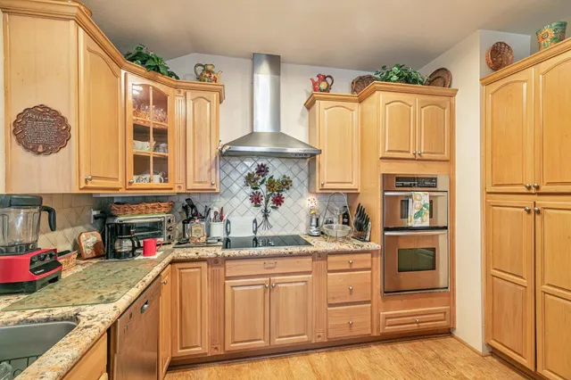 a kitchen with stainless steel appliances granite countertop a sink and a stove