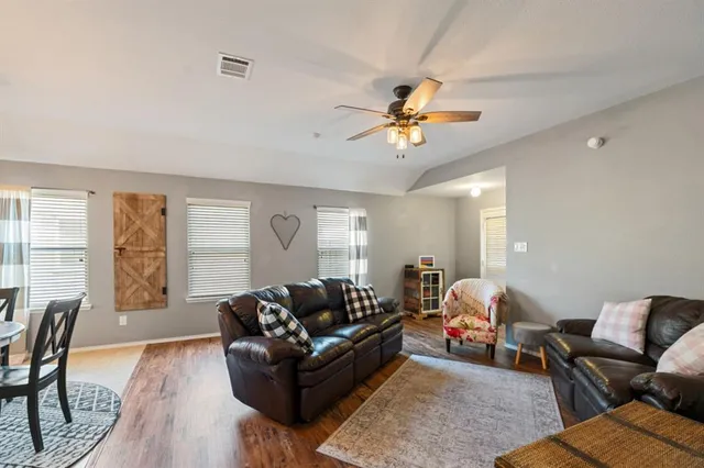 a living room with furniture wooden floor and a window