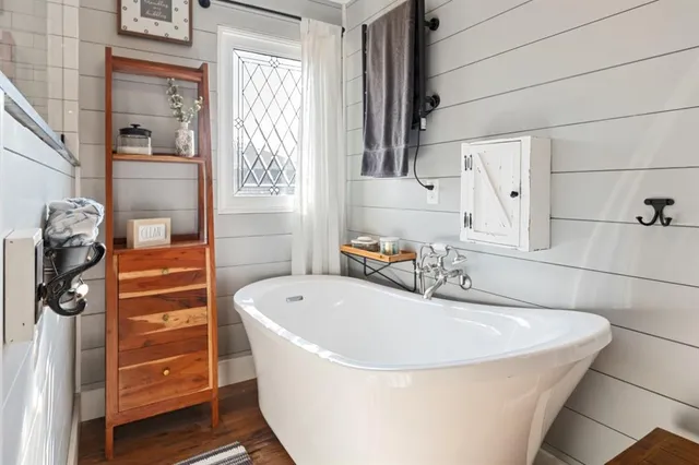 a bathroom with a tub a sink and a window