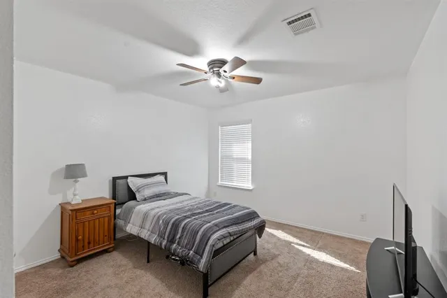 a bedroom with a bed and a ceiling fan