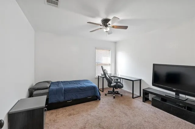 a bedroom with furniture and a flat screen tv