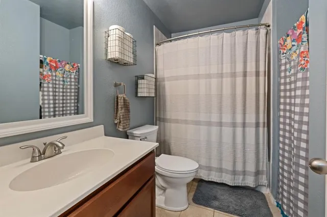 a bathroom with a sink a toilet and shower curtain