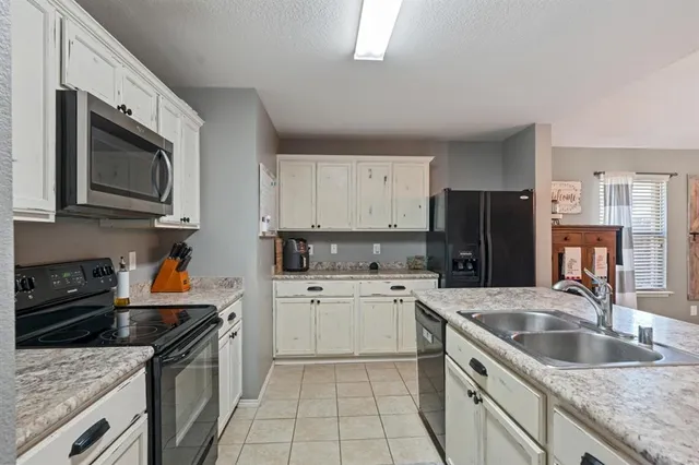 a kitchen with a sink stove top oven and refrigerator