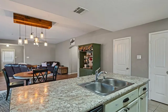 a kitchen with a table chairs and chandelier