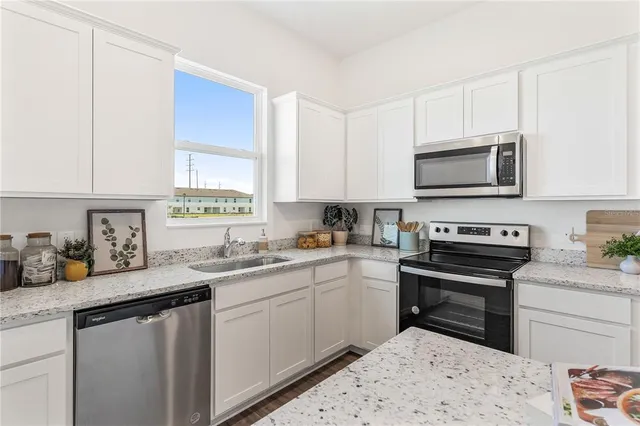 a kitchen with a sink stove and microwave