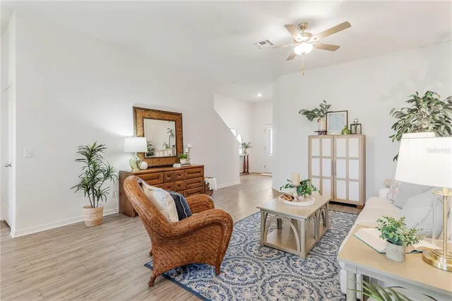 a living room with furniture a chandelier and a potted plant