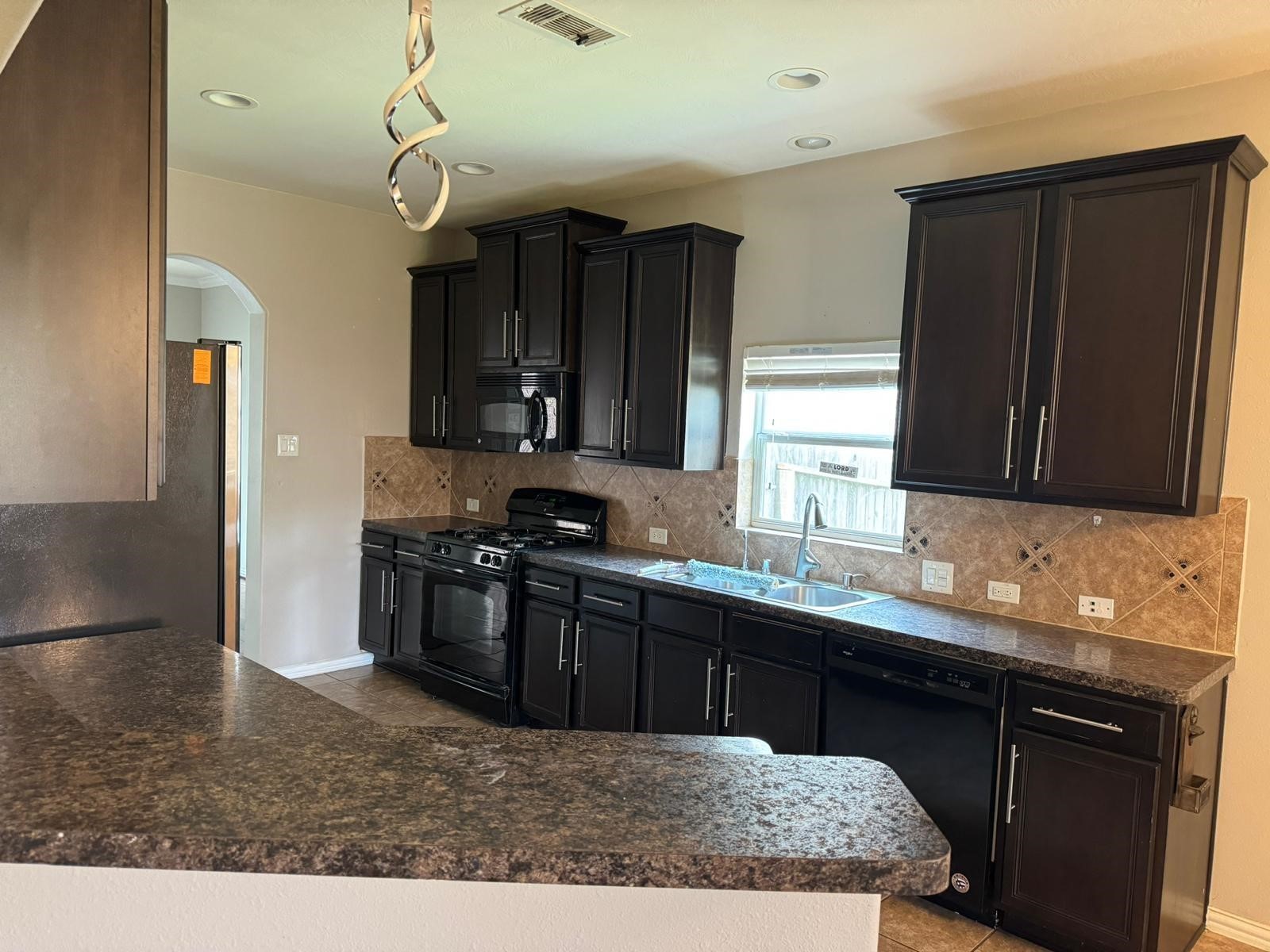 25614 Crisp Spring Lane Spring, TX 77373 - Photo 5 of 25 a kitchen with kitchen island granite countertop a sink stainless steel appliances and cabinets