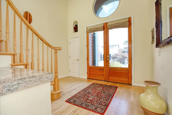 a view of an entryway with wooden floor and mirror