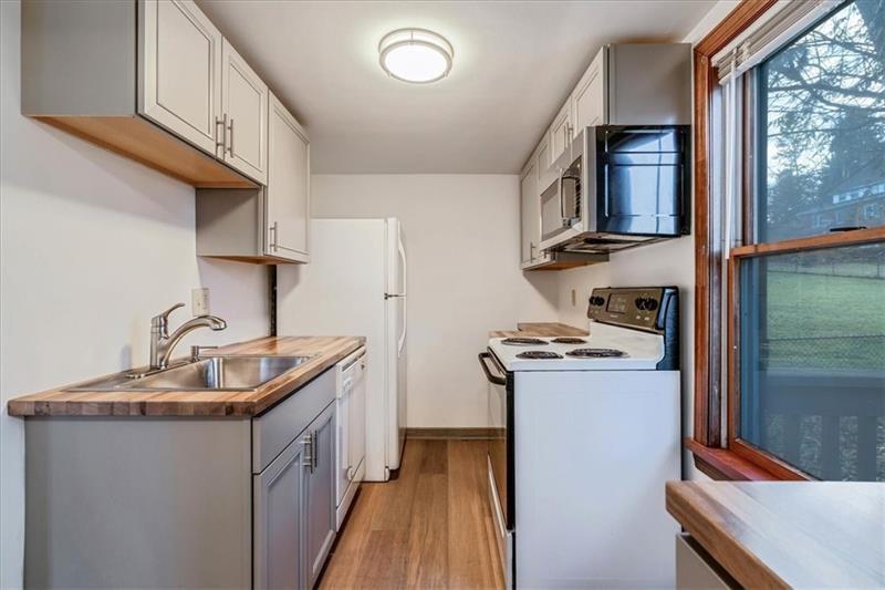 2057 Washington Road, Unit B Pittsburgh, PA 15241 - Photo 4 of 9 a kitchen with stainless steel appliances granite countertop a sink stove and refrigerator