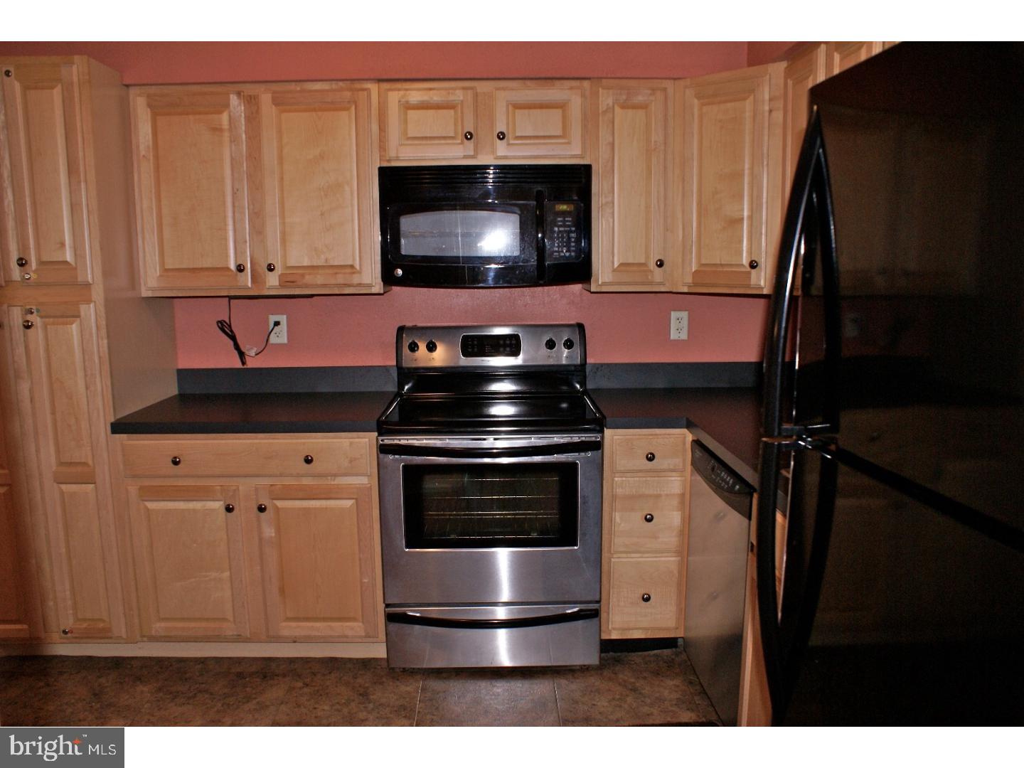 64 Welsh Tract Road, Unit 301 Newark, DE 19713 - Photo 8 of 15 a kitchen with stainless steel appliances a stove a microwave oven cabinets and a sink