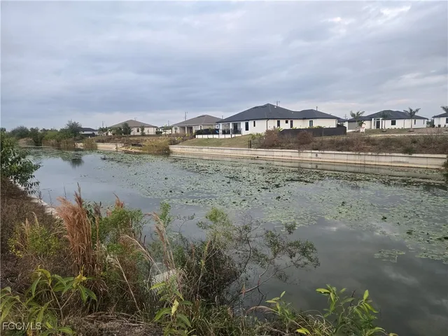 a view of a lake with houses in back
