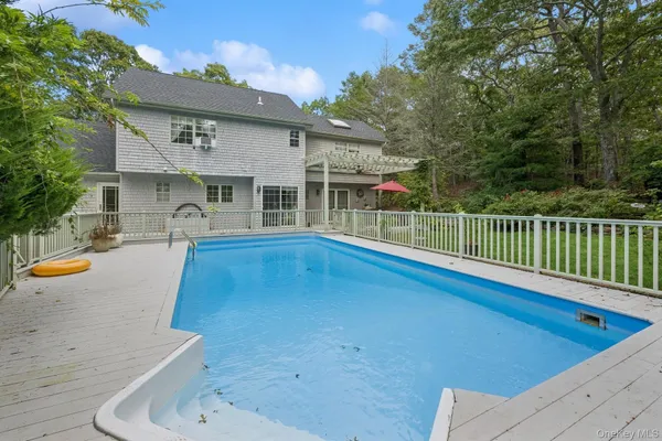 a view of a house with pool and chairs