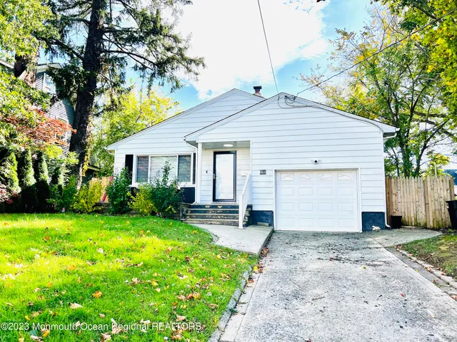 a view of a house with a yard and large tree