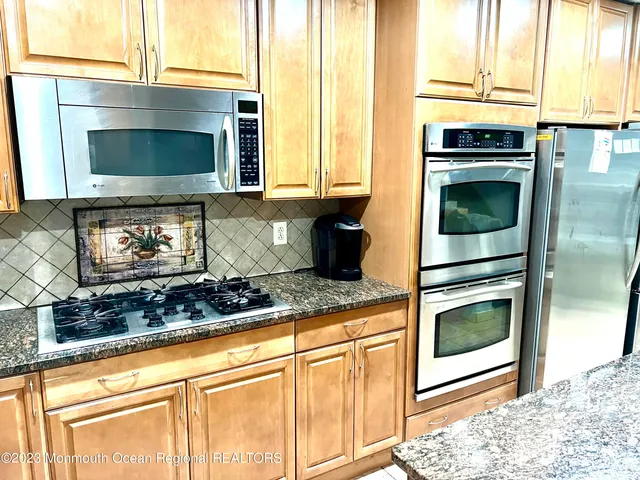 a kitchen with granite countertop a stove and a microwave