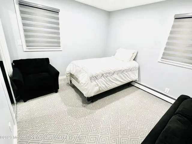 a bedroom with a bed window and chair