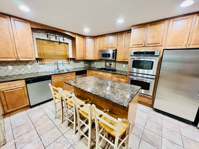 a kitchen with granite countertop a stove top oven microwave and cabinets