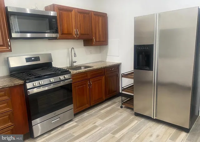 a kitchen with stainless steel appliances granite countertop a stove a microwave and a refrigerator
