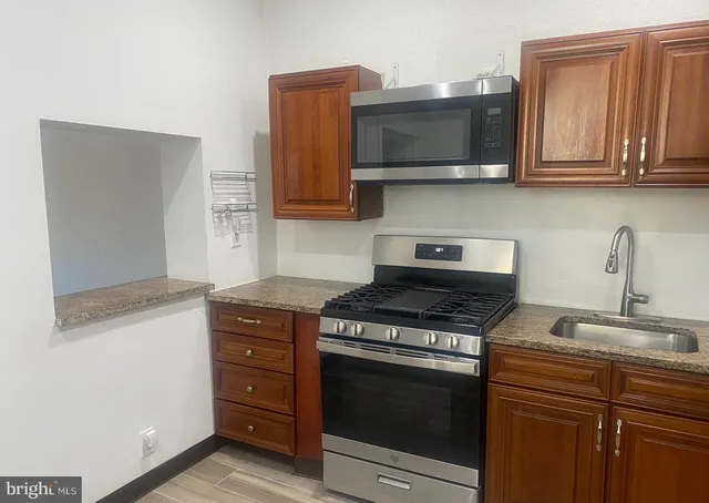 a kitchen with stainless steel appliances granite countertop a stove microwave and oven