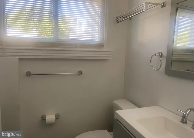 a bathroom with a sink a toilet and a window