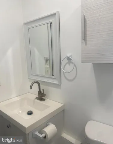 a bathroom with a toilet sink and mirror