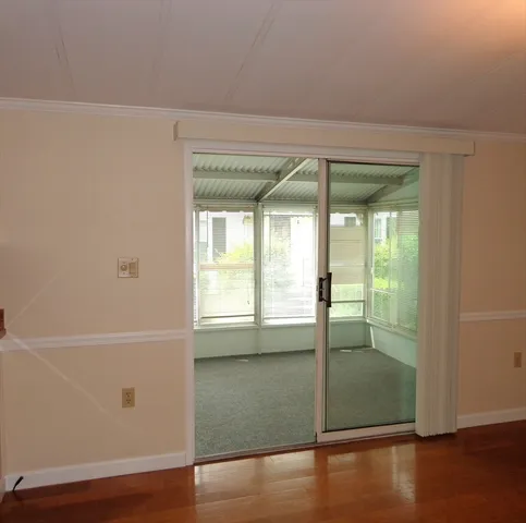 an empty room with wooden floor and window