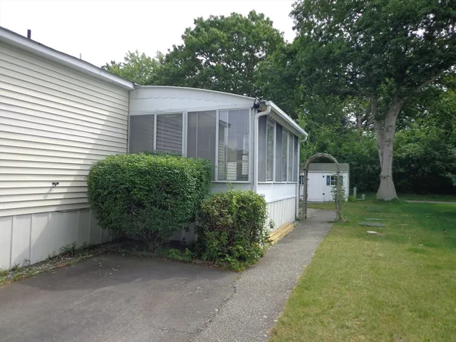 a view of a patio with a table and chairs and a barbeque