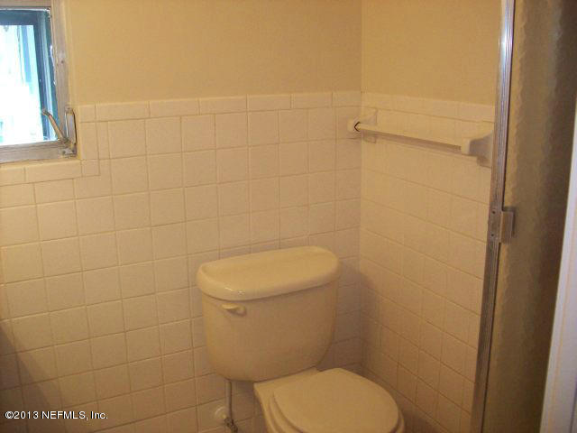 3750 Heath Road Jacksonville, FL 32277 - Photo 8 of 12 a white toilet sitting next to a shower in a bathroom
