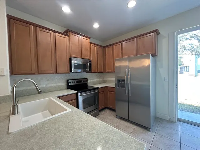 a kitchen with granite countertop a refrigerator and a sink
