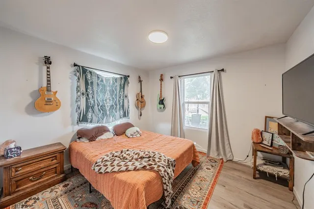 a bedroom with a bed and wooden floor