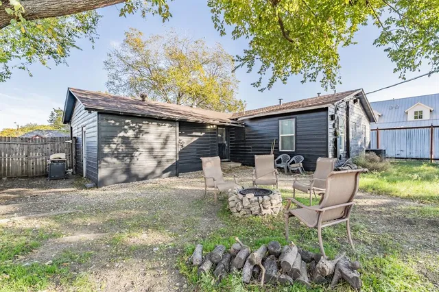 a view of a patio with table and chairs and potted plants with wooden floor and fence