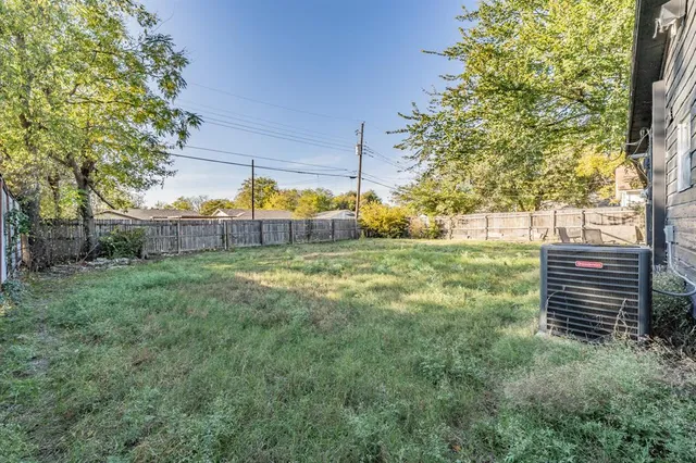 a view of a backyard with table and chairs and wooden fence