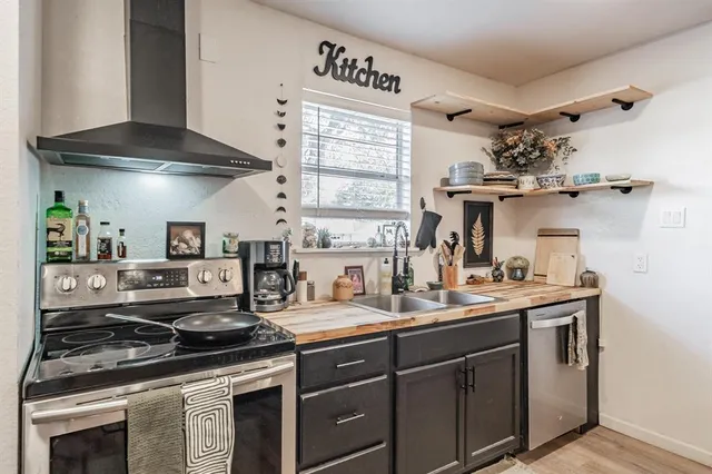 a kitchen with stainless steel appliances a sink stove and cabinets