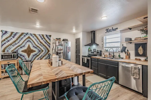 a kitchen with stainless steel appliances granite countertop a stove a sink dishwasher and cabinets with wooden floor