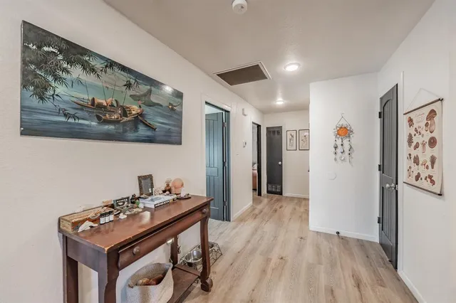 a view of a hallway with workspace and lots of furniture
