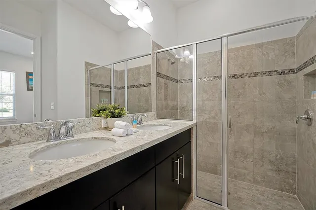 a bathroom with double vanity sinks and a mirror