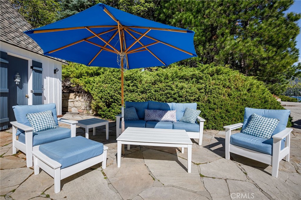 28641 North Shore Road Lake Arrowhead, CA 92352 - Photo 43 of 75 a view of a patio with a table and chairs under an umbrella