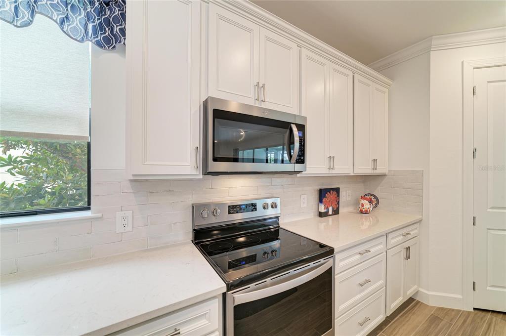 16341 Hidden Oak Loop Lakewood Ranch, FL 34211 - Photo 20 of 76 a kitchen with stainless steel appliances white cabinets and a stove top oven