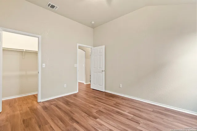 a view of an empty room with wooden floor