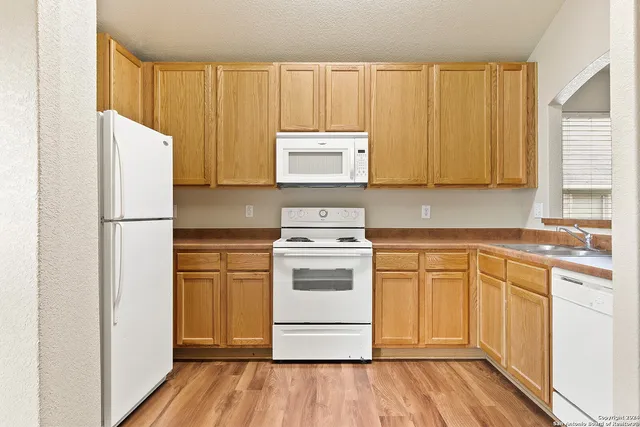 a kitchen with a stove a refrigerator and cabinets