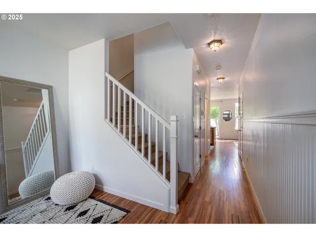 a view of a hallway with wooden floor and furniture