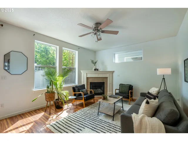 a living room with furniture a fireplace and a large window