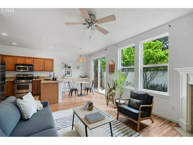 a living room with furniture kitchen area and a window