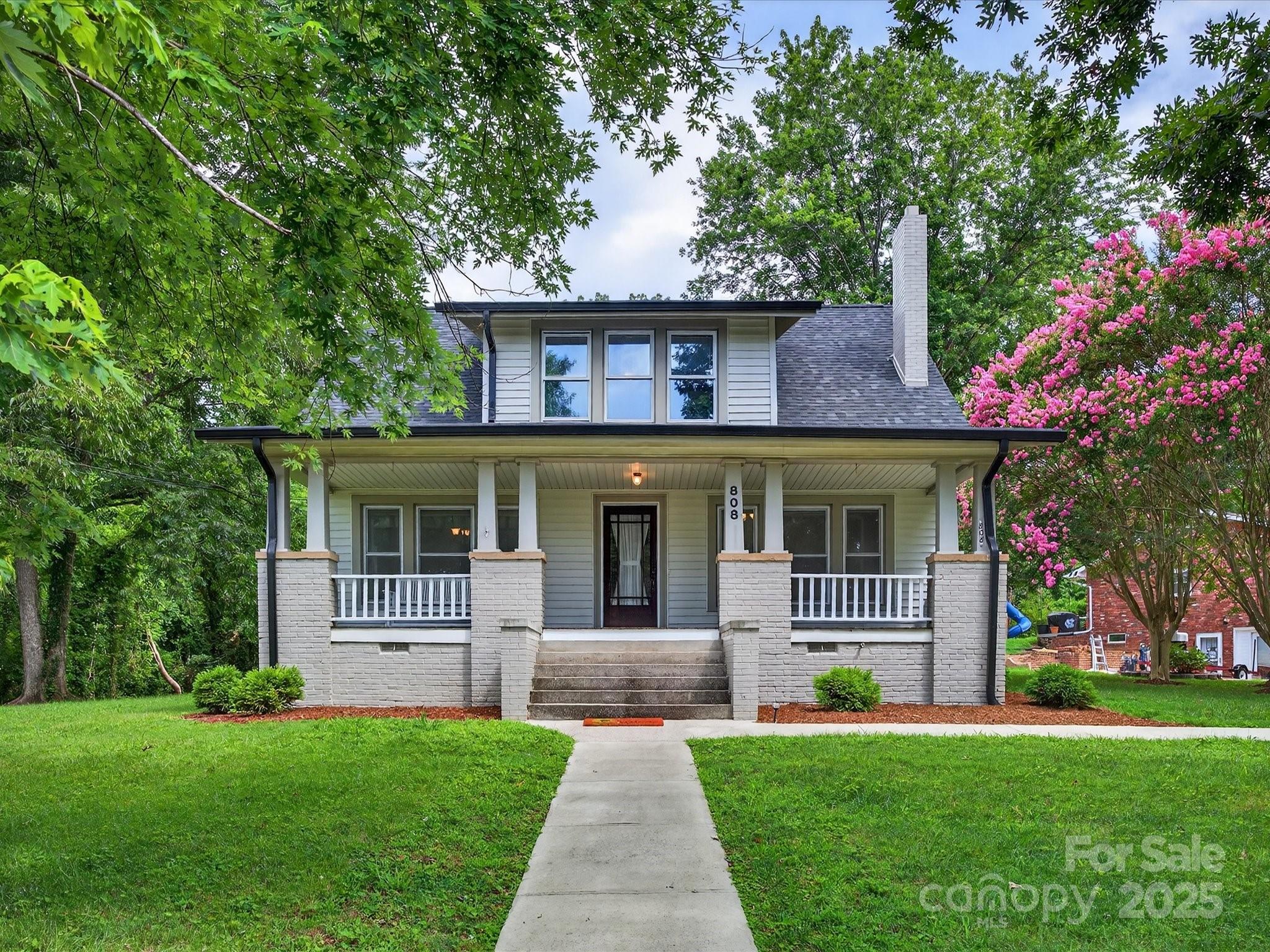 a front view of a house with a garden and yard