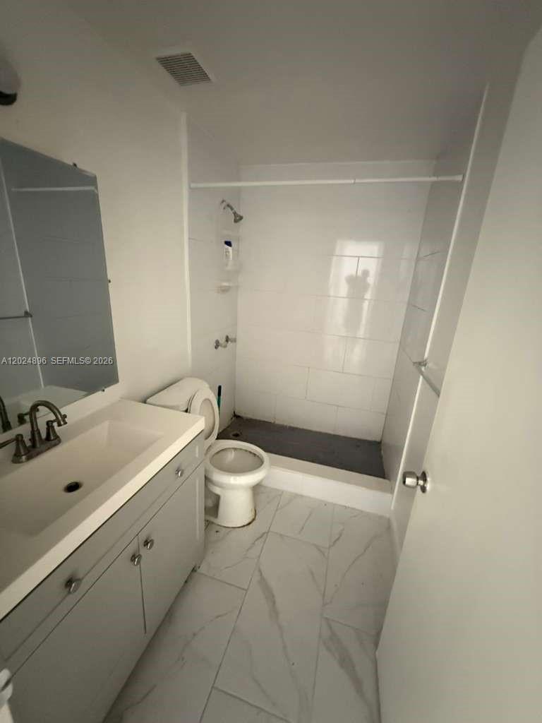 6921 Pembroke Road, Unit 6927 Pembroke Pines, FL 33023 - Photo 3 of 10 a bathroom with a sink a toilet and shower