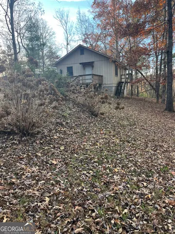 a view of a wooden house with a yard