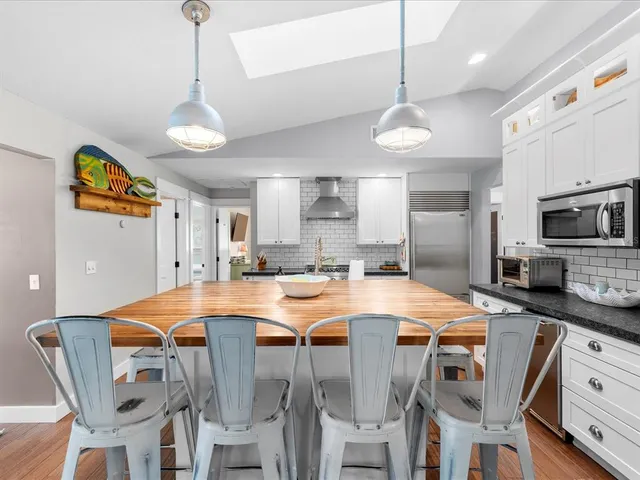 a room with kitchen island granite countertop furniture and a flat screen tv