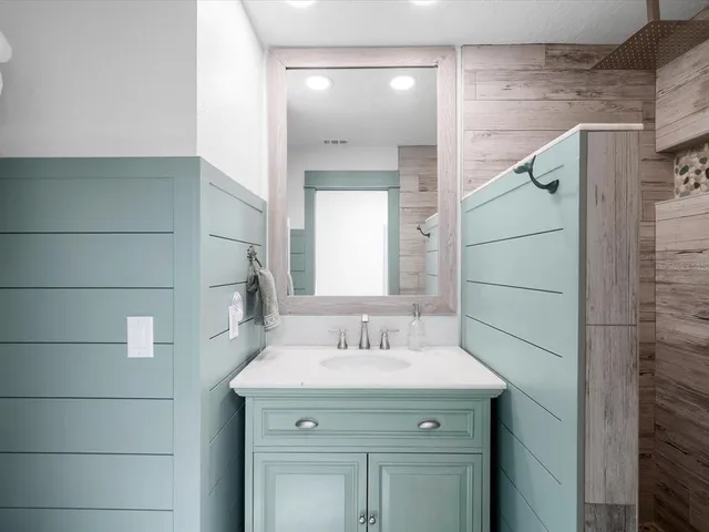 a bathroom with a toilet sink vanity and mirror