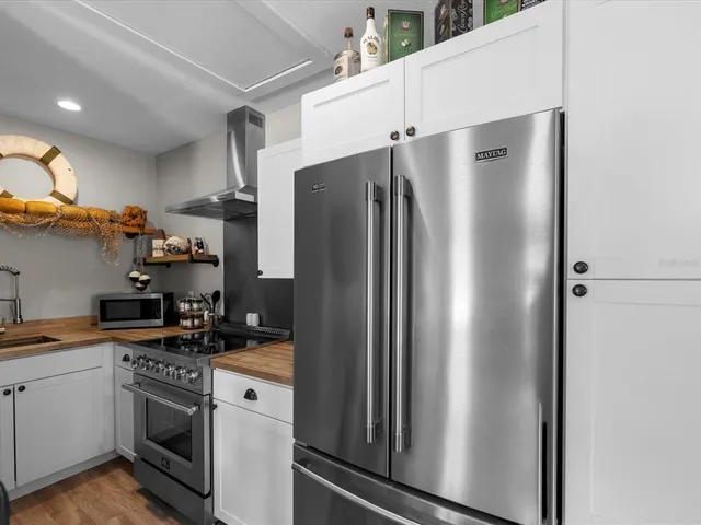 a view of a house with a yard and large trees