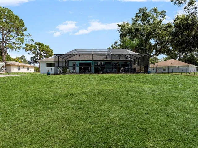 an aerial view of residential houses with outdoor space and trees