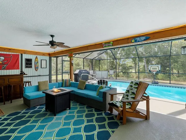 a kitchen with stainless steel appliances granite countertop a dining table chairs refrigerator and microwave